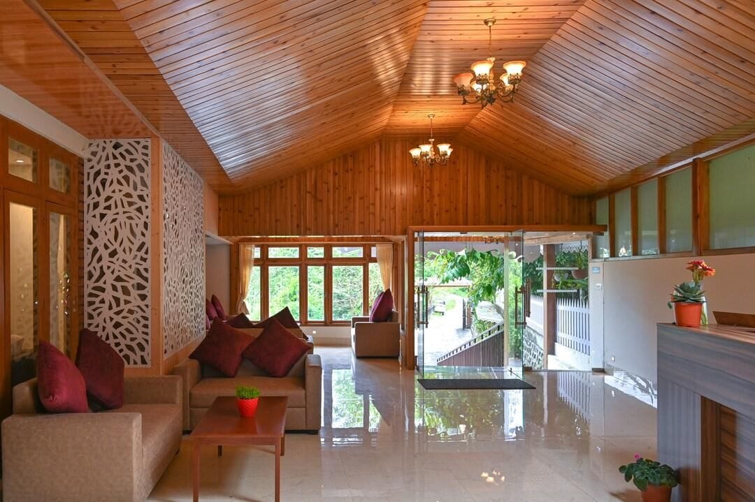 A spacious room with a high ceiling, wooden paneling, a sofa, a coffee table, and a fireplace.