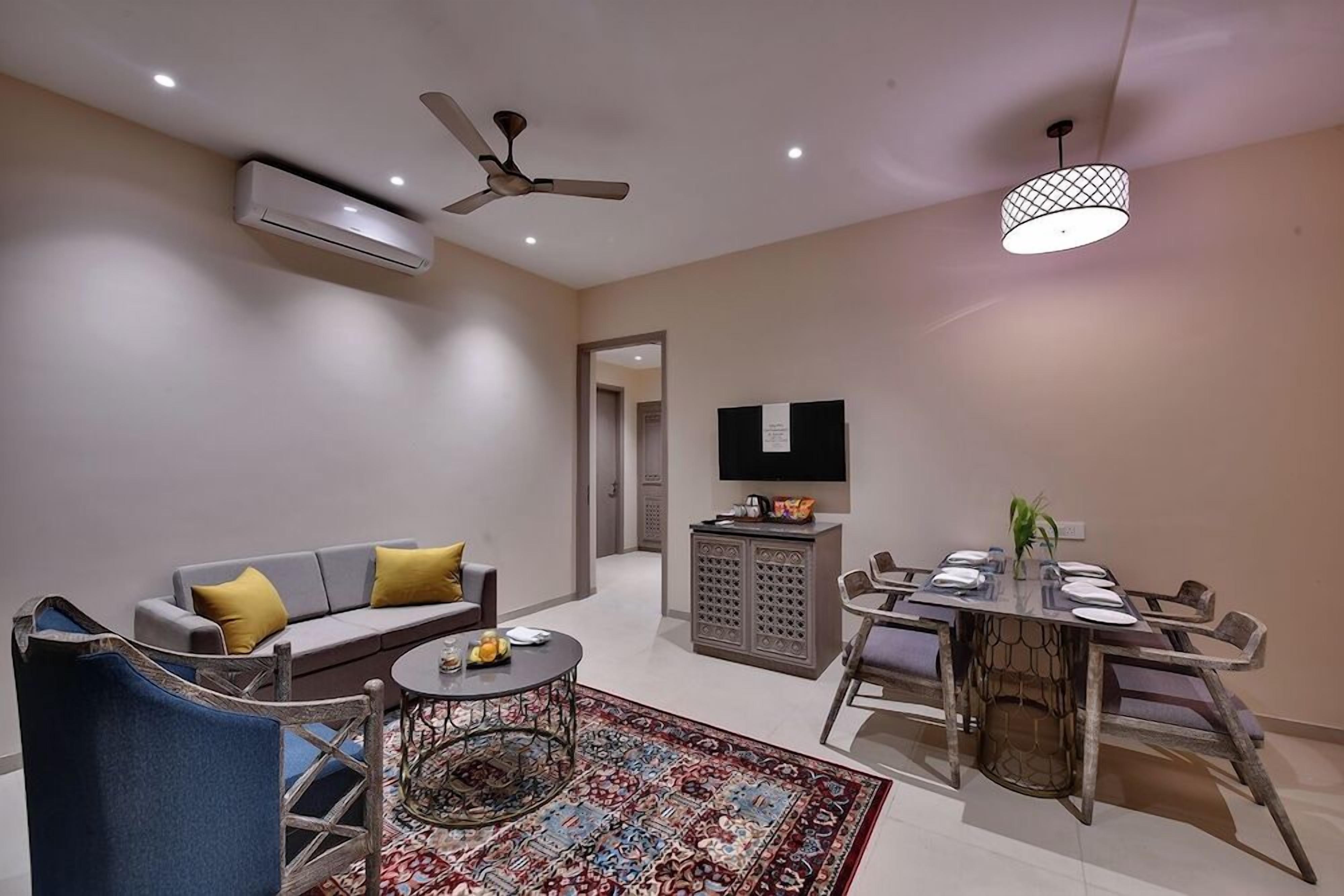 A modern living room with a sofa, coffee table, and dining area.