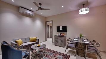 A modern living room with a sofa, coffee table, and dining area.