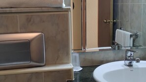 Ein Badezimmer mit Marmorwaschbecken, Handtuchhalter und Spiegel.