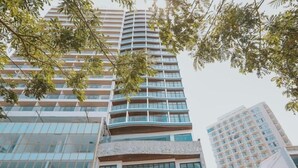 A high-rise building with multiple balconies and a glass facade. - La Vague Hotel (Nha Trang)