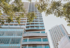 Un immeuble de grande hauteur doté de nombreux balcons et d’une façade en verre.