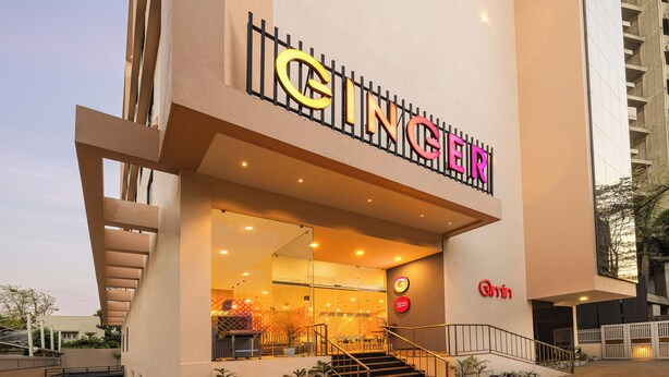 A building with a prominent 'GINGER' sign, a staircase leading to the entrance, and a 'Qmin' logo on the wall. - Ginger Nagpur City Centre (Nagpur)