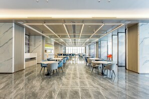 Una sala de conferencias amplia y moderna con una larga mesa, sillas y un panel de vidrio.