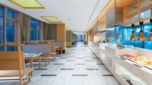 A modern hotel lobby with a long reception desk, seating area, and a buffet counter. - Holiday Inn Dujiangyan Ancient Town (Chengdu)