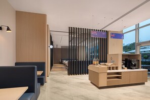 Um restaurante moderno com cabines e balcão. Há placas indicando direções e uma máquina de café.