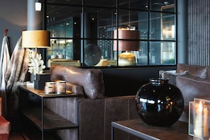A modern interior with leather seating, a large vase, and a lamp on a table.