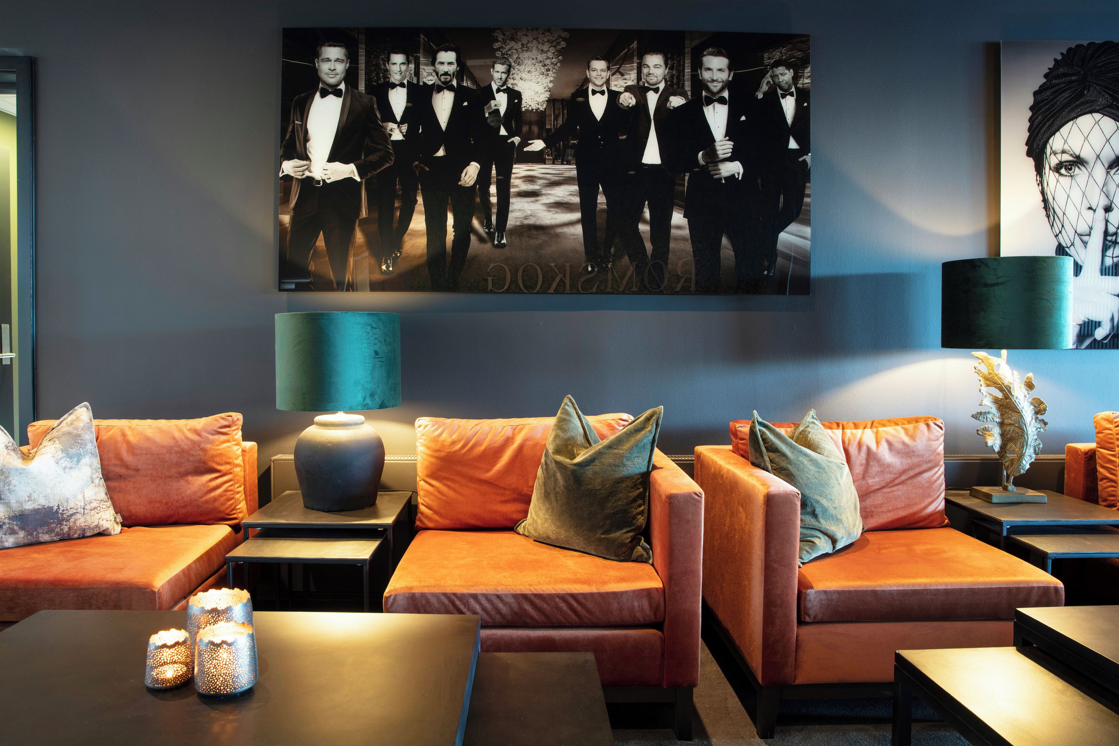 Un espace de détente moderne avec des canapés en cuir, une grande photographie encadrée au mur et un vase décoratif posé sur une table d’appoint.