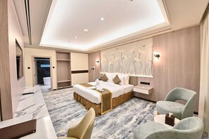 A modern hotel room with a large bed, a desk, and a seating area. - Pavilion Palace Hotel (Sharjah)