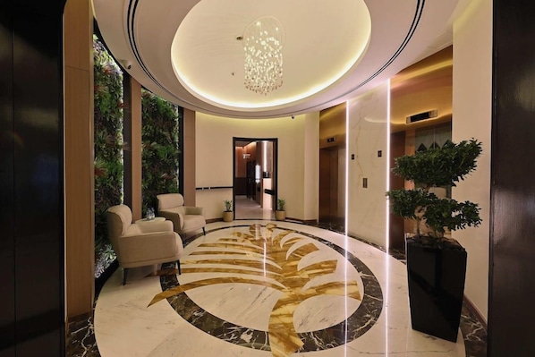 A modern lobby with a circular marble floor, a chandelier, and a seating area. - Pavilion Palace Hotel (Sharjah)