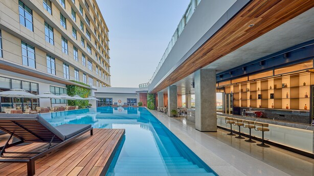 A modern hotel with a swimming pool, outdoor bar, and lounge area. - VM Hotel (Phnom Penh)