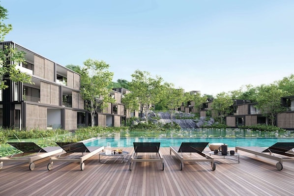 Um resort moderno com piscina, espreguiçadeiras e vista para uma cascata.