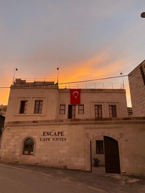 Un bâtiment sur lequel on peut lire l’inscription « ESCAPE CAVE SUITES » et qui arbore un drapeau rouge orné d’un croissant et d’une étoile.