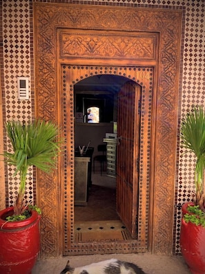 An ornate wooden door with intricate carvings and a number '104' above it. - Riad BAB Yacout Piscine and SPA (Marrakech)