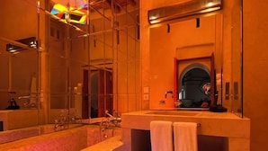 Een moderne badkamer met een grote spiegel, een bad en een douchehoek.