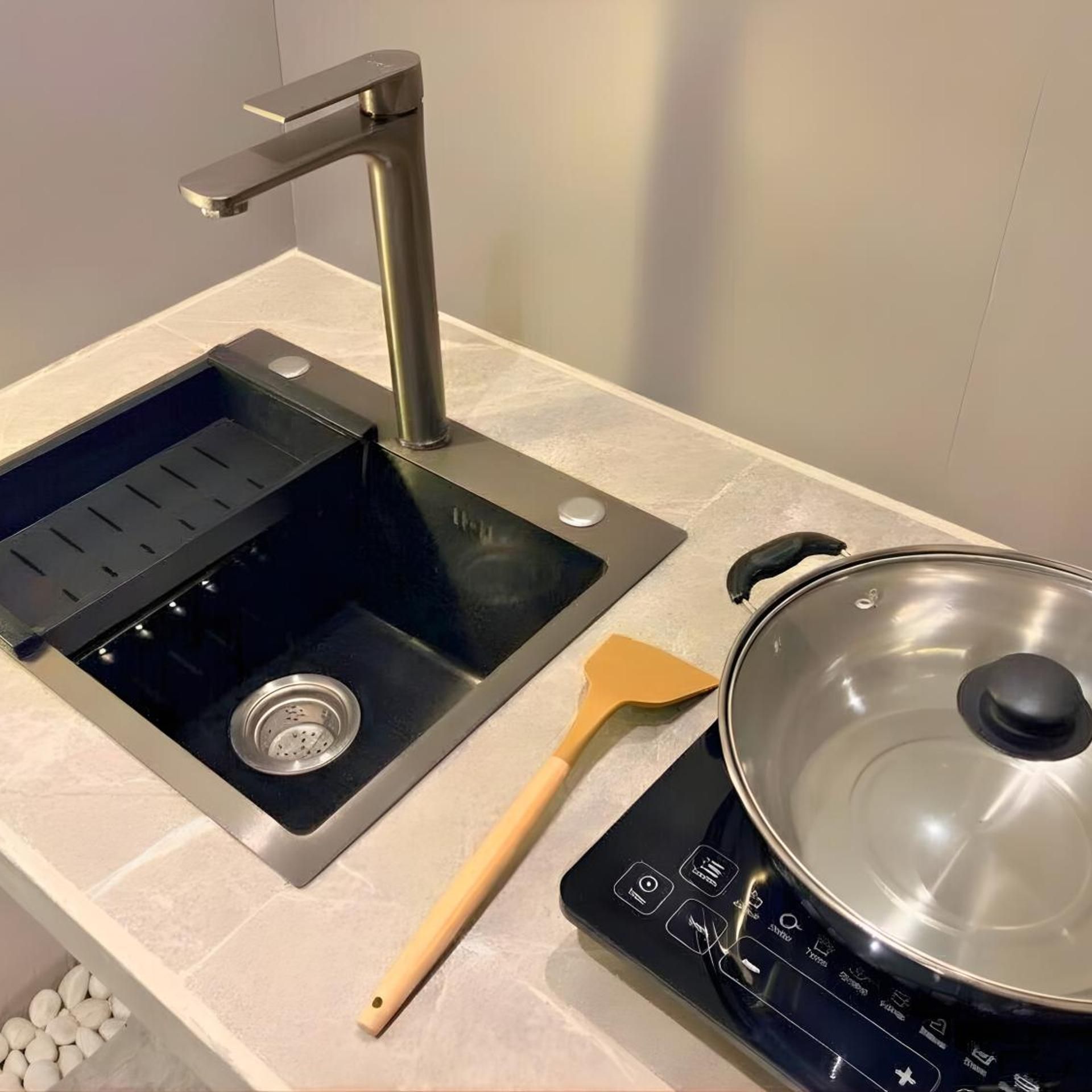 A kitchen with a sink, stove, and a spatula.