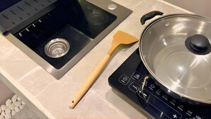 Una cocina con un lavaplatos, estufa y una espátula.