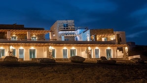 A coastal building with multiple rooms, a balcony, and a stone facade. - Anemela Mykonos Villas & Suites (Mykonos)