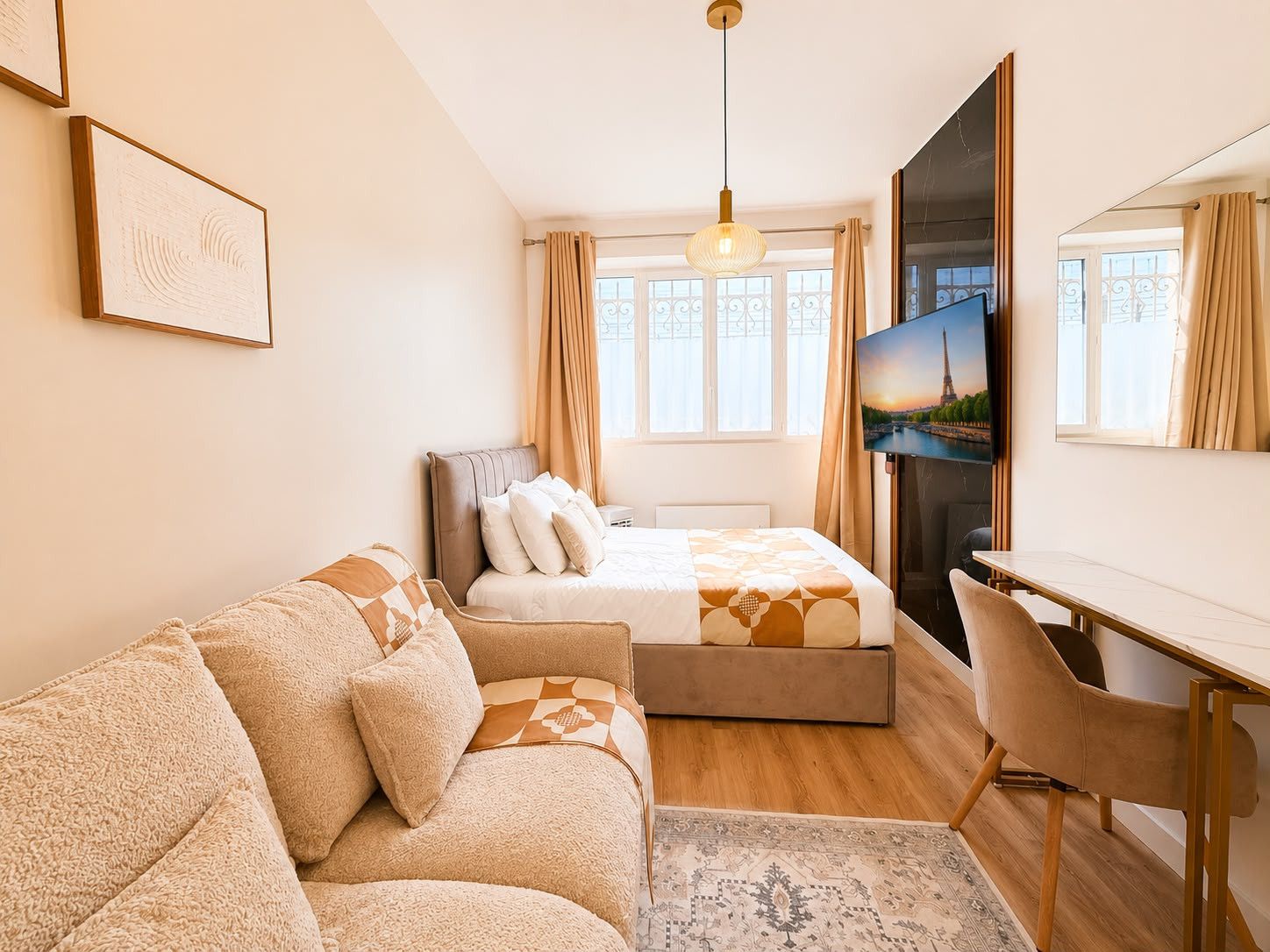 Ein Schlafzimmer mit Bett, Sofa, Schreibtisch und Fernseher.