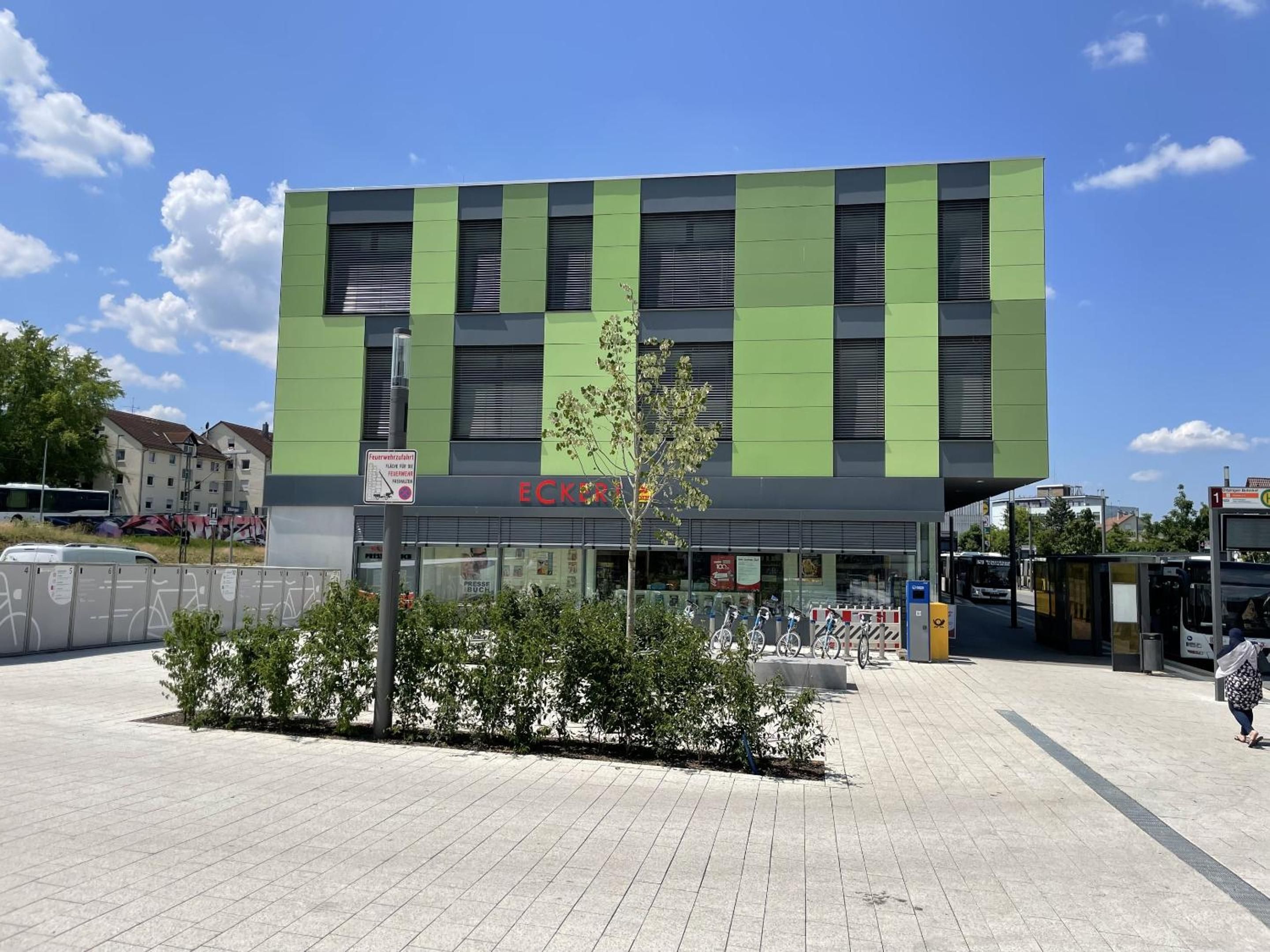 A modern building with a green facade and a sign that reads 'ECKER'.
