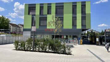 A modern building with a green facade and a sign that reads 'ECKER'.