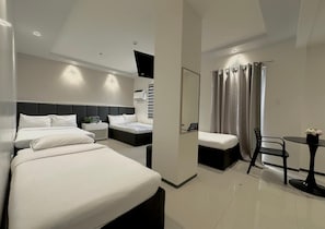 A modern hotel room with two beds, a small table, and a shower area. - Central Block Inn (Bacolod)