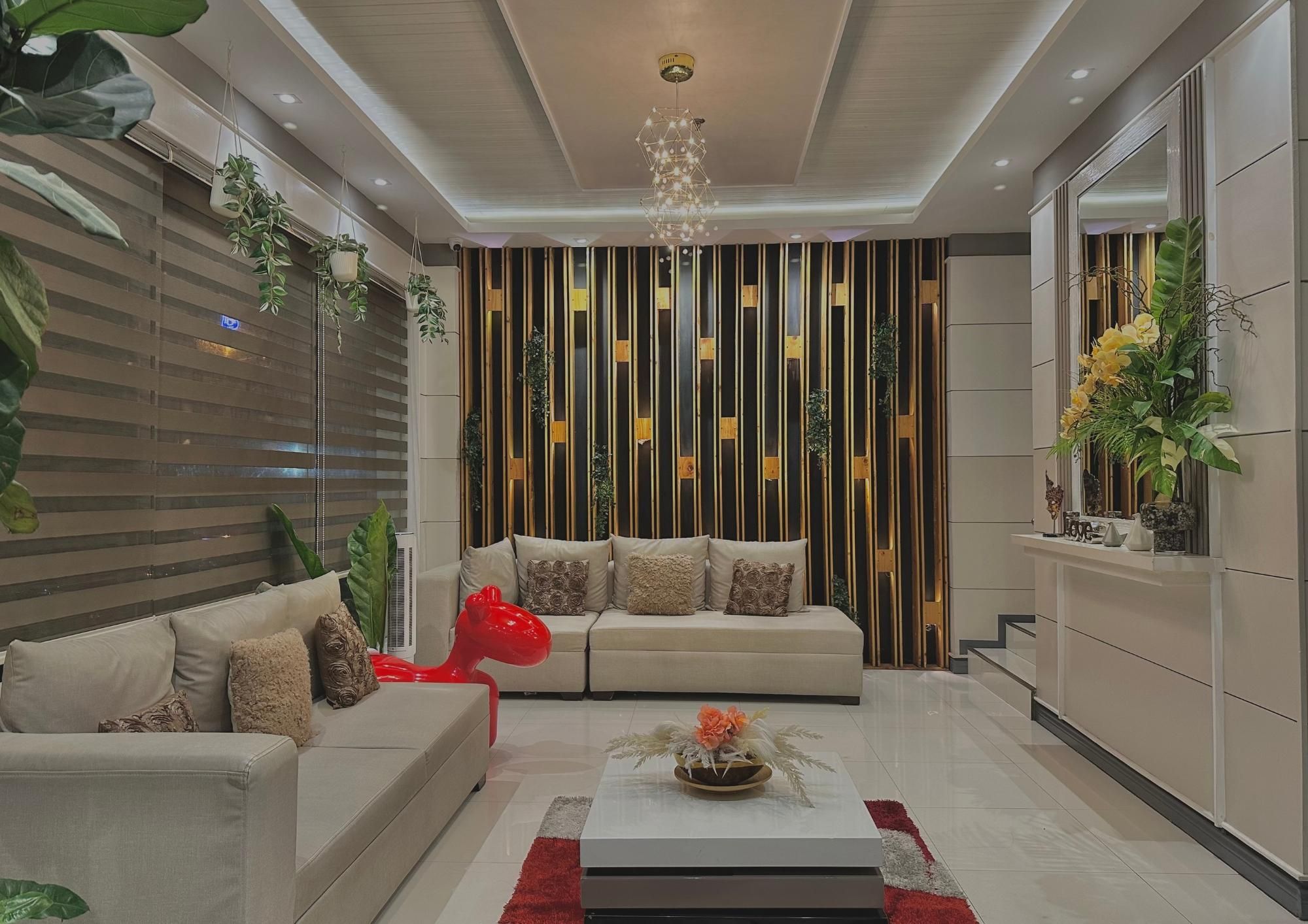 A modern living room with a sofa set, a coffee table, and a decorative red sculpture.