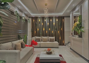 A modern living room with a sofa set, a coffee table, and decorative plants. - Central Block Inn (Bacolod)