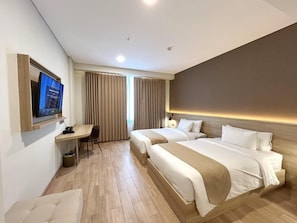 Een hotelkamer met twee bedden, een bureau, een stoel en een televisietoestel.
