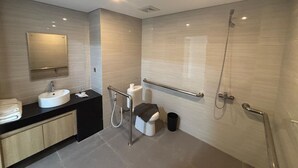 Un baño moderno con lavamanos, espejo, inodoro y ducha.