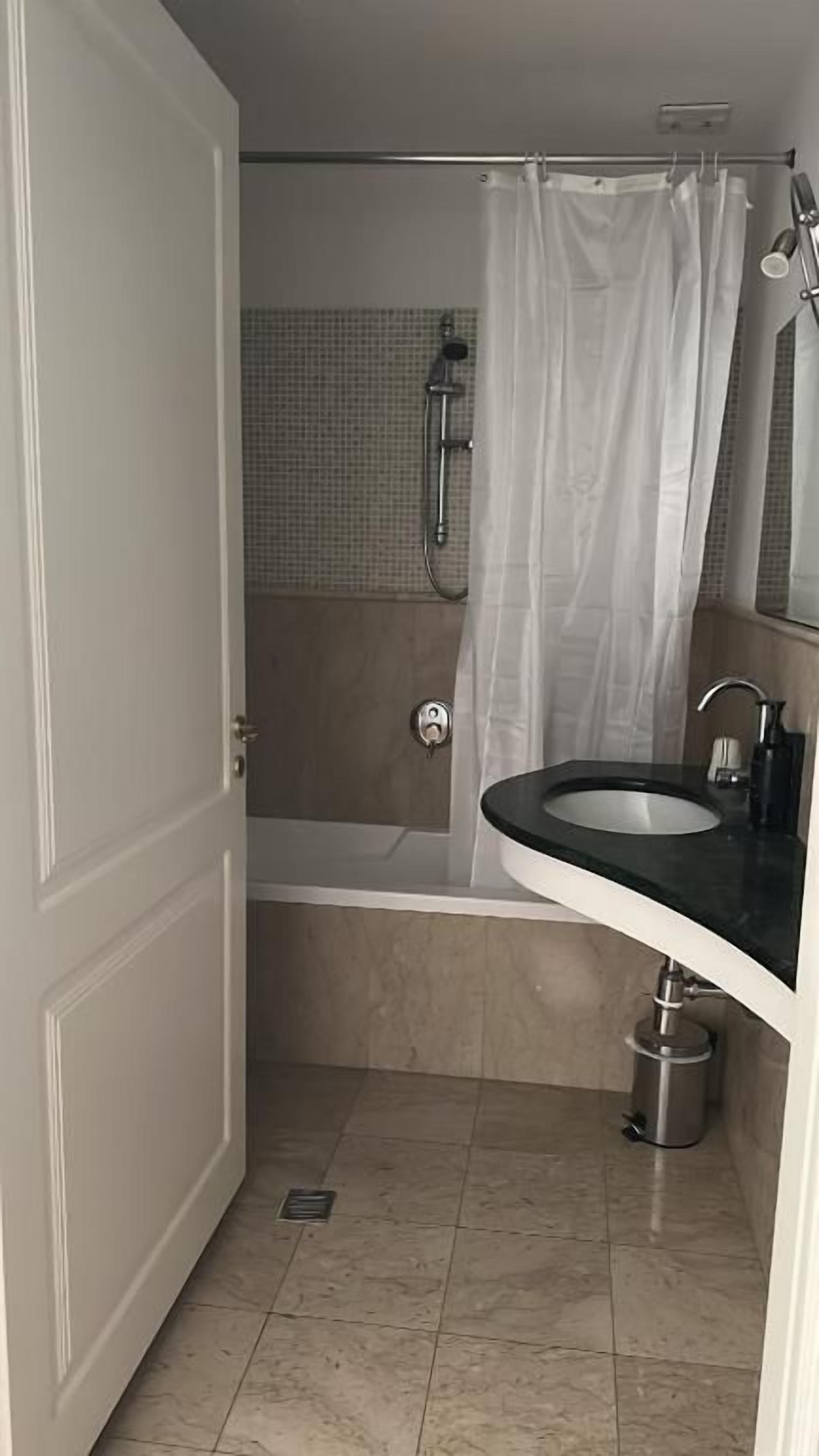 Een badkamer met een bad, wastafel en douche.