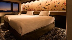 Quarto de hotel com uma cama grande, cabeceira com painel decorativo, mesa de cabeceira e janela com vista.