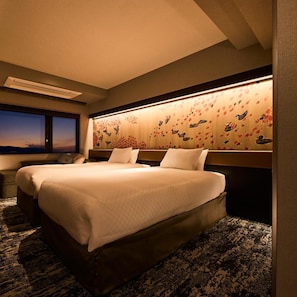 Camera d'albergo con un letto grande, una testiera decorata, un comodino e una finestra con vista.