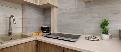 Una cocina moderna con horno integrado, un lavabo y armarios de madera.