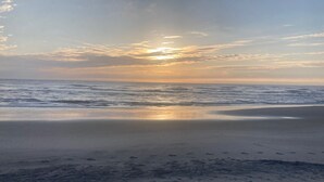 Una platja amb mar tranquil·la i un capvespre.