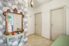 A room with a large mirror, a green console table, and two doors. - Stanze Letterarie - 'Giovanni Verga' (Catania)