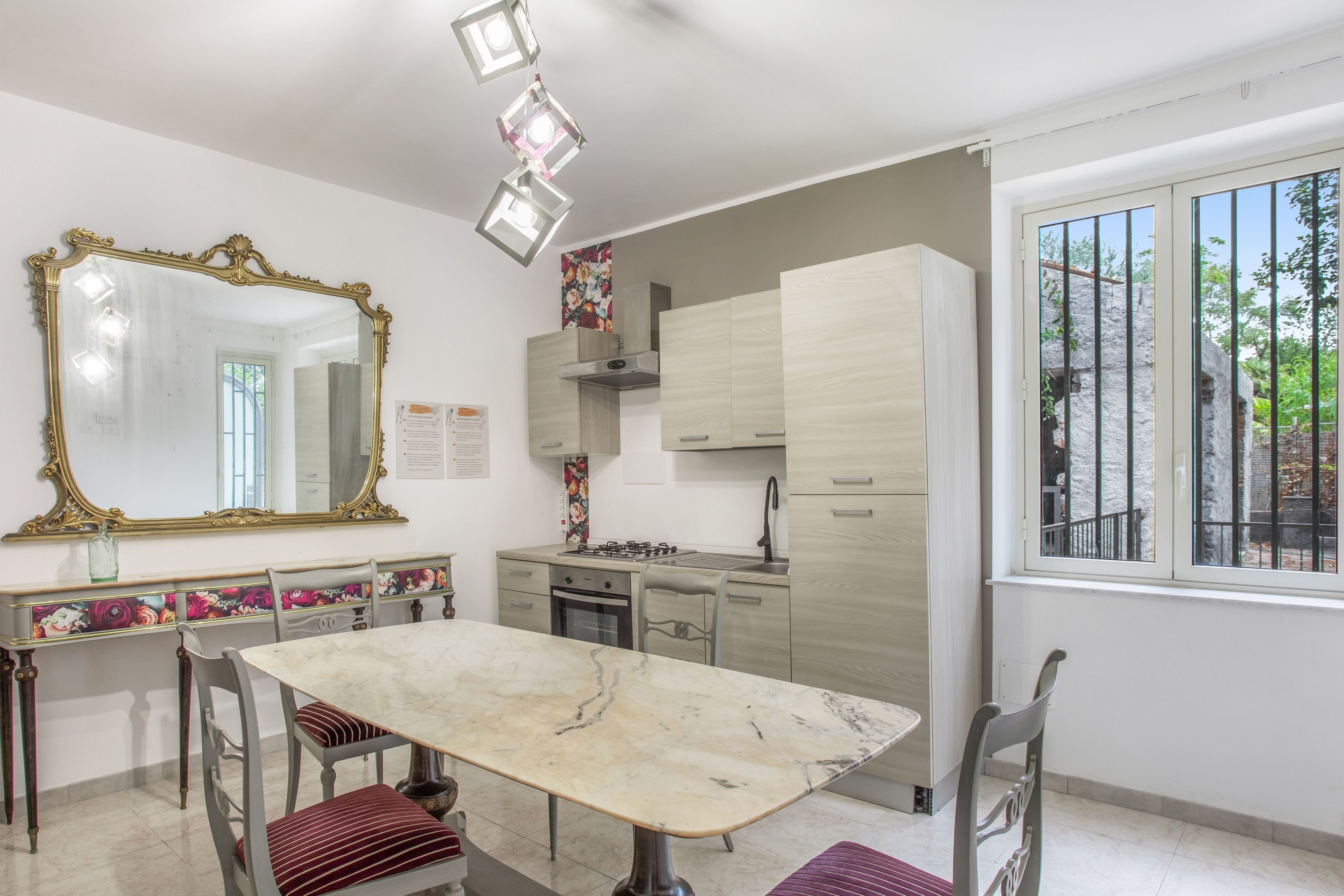A modern kitchen with a marble countertop, a gas stove, and a sink.