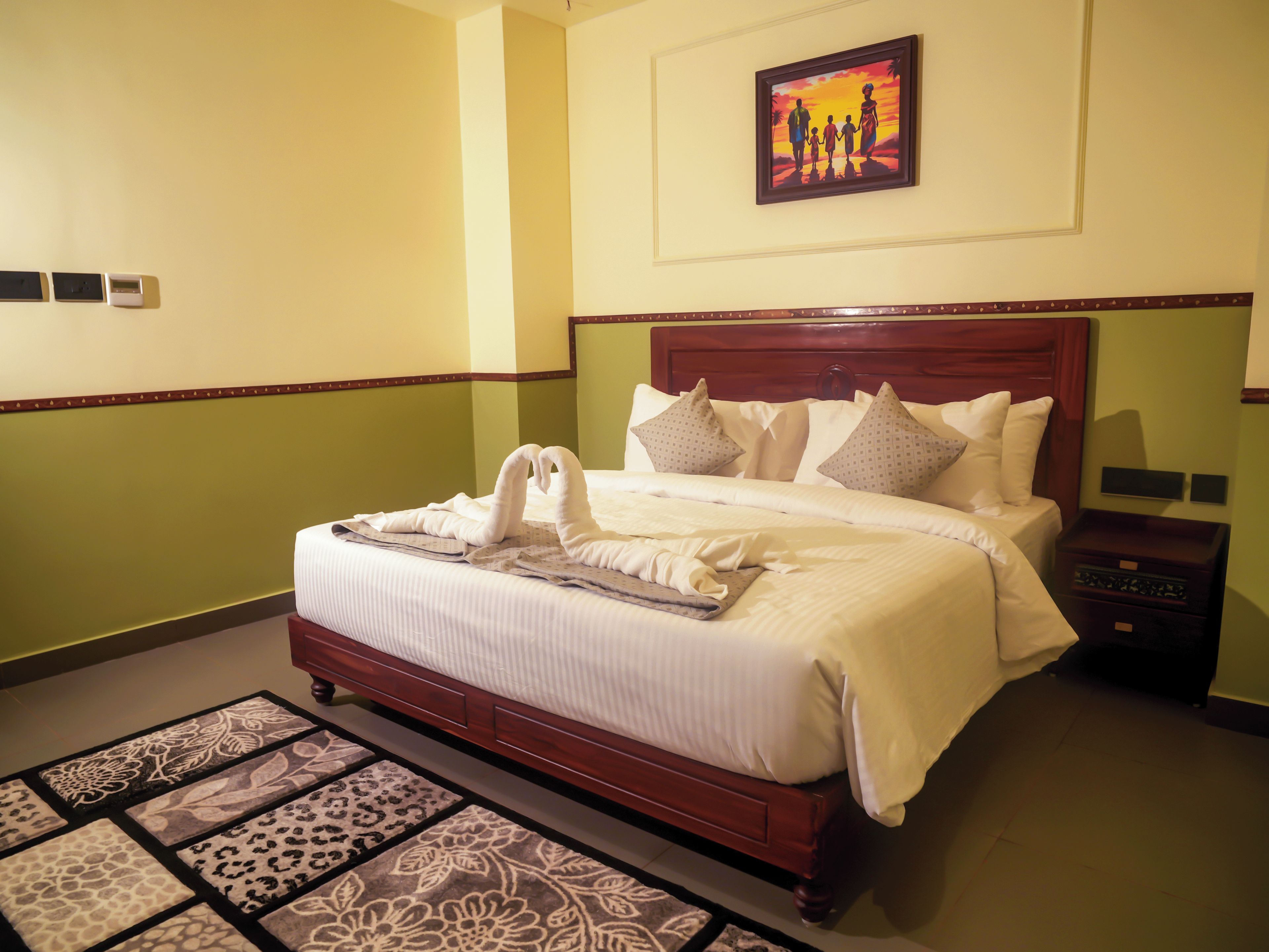 A neatly made bed with a headboard, a bedside table, and a nightstand.