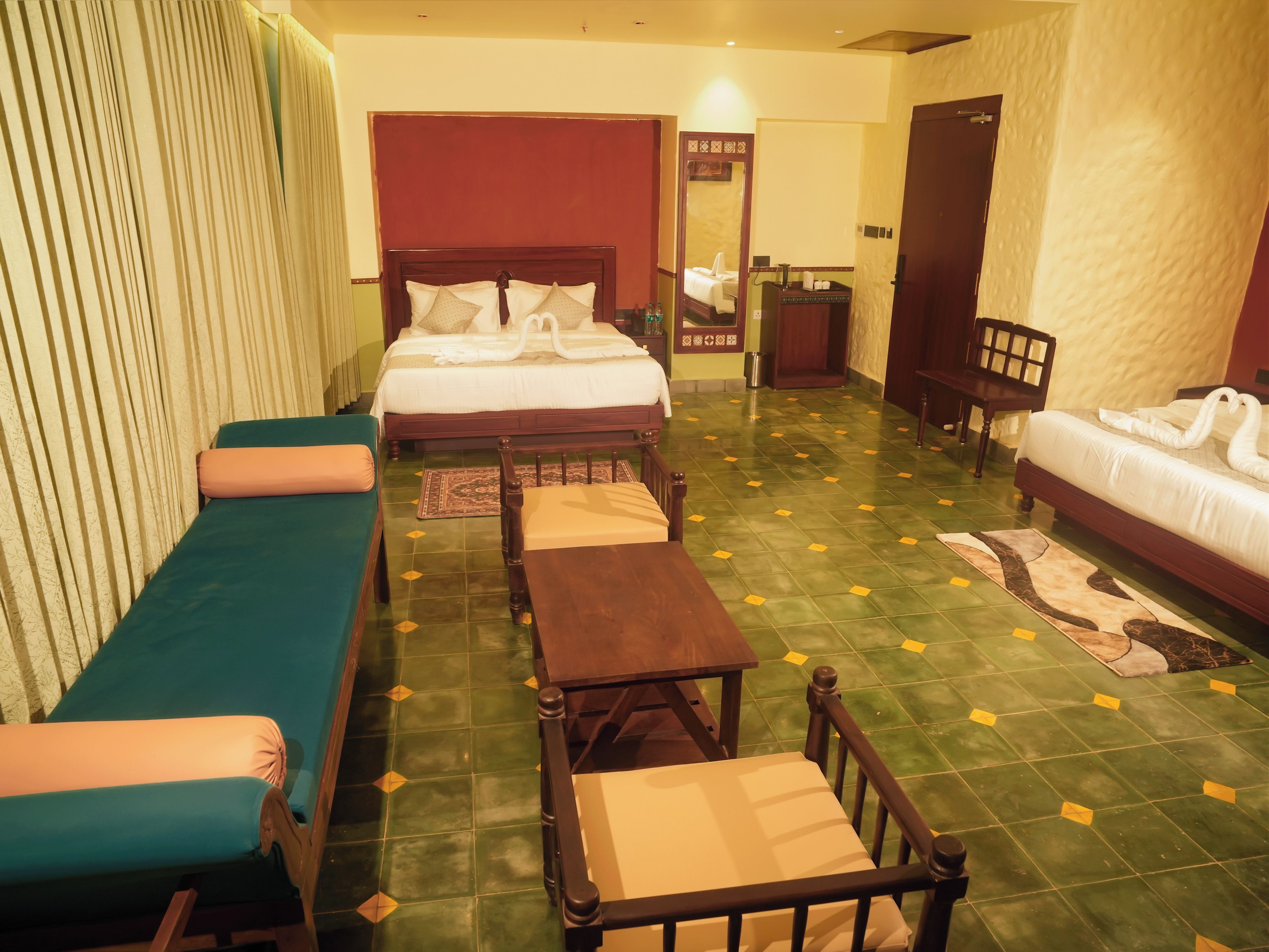 A hotel room with a bed, a sofa, a table, and a chair.