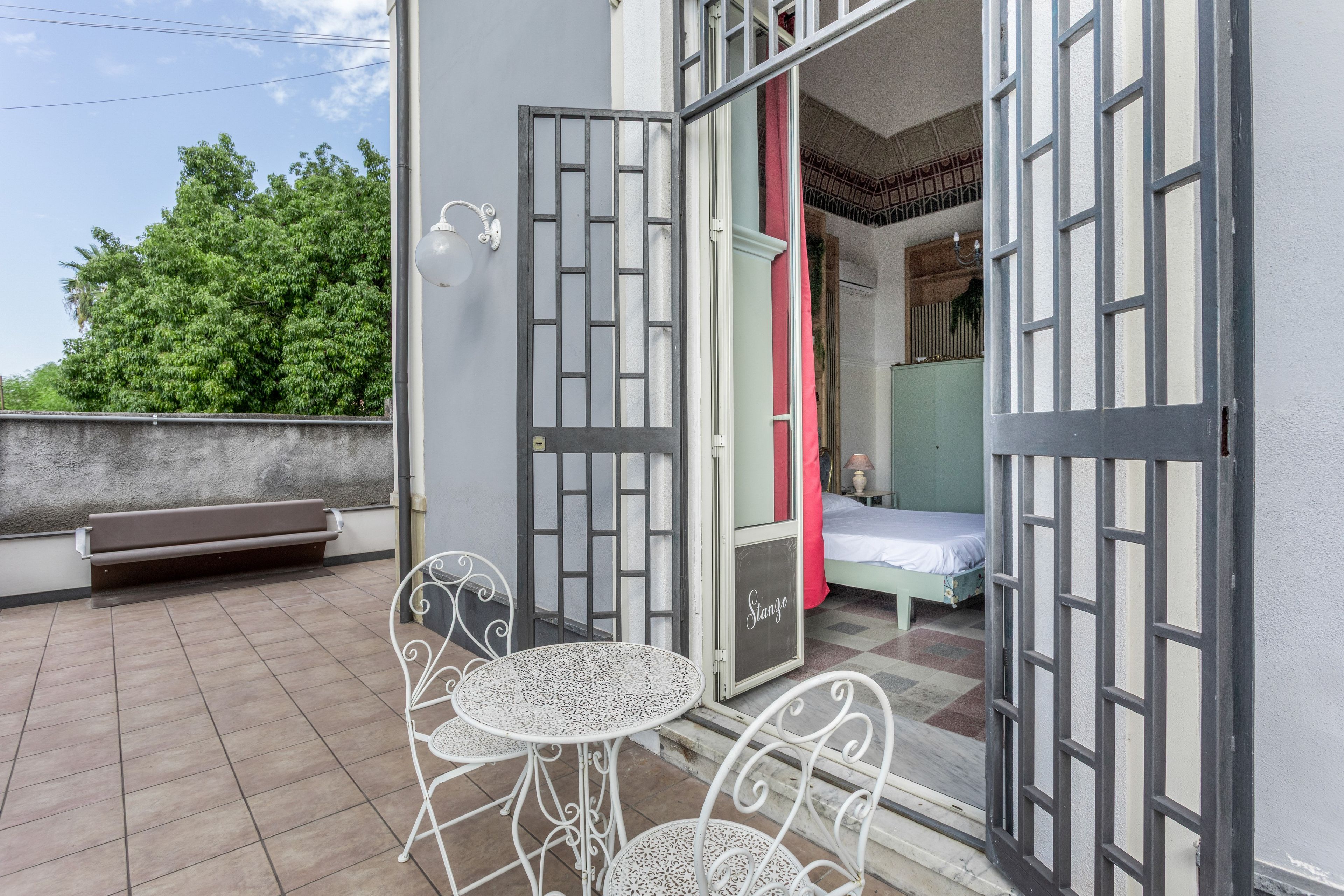 A room with a bed, a bench, and a table with chairs.