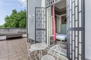 A room with a bed, a bench, and a table with chairs. - Stanze Letterarie – 'Rosa Balistreri' (Catania)