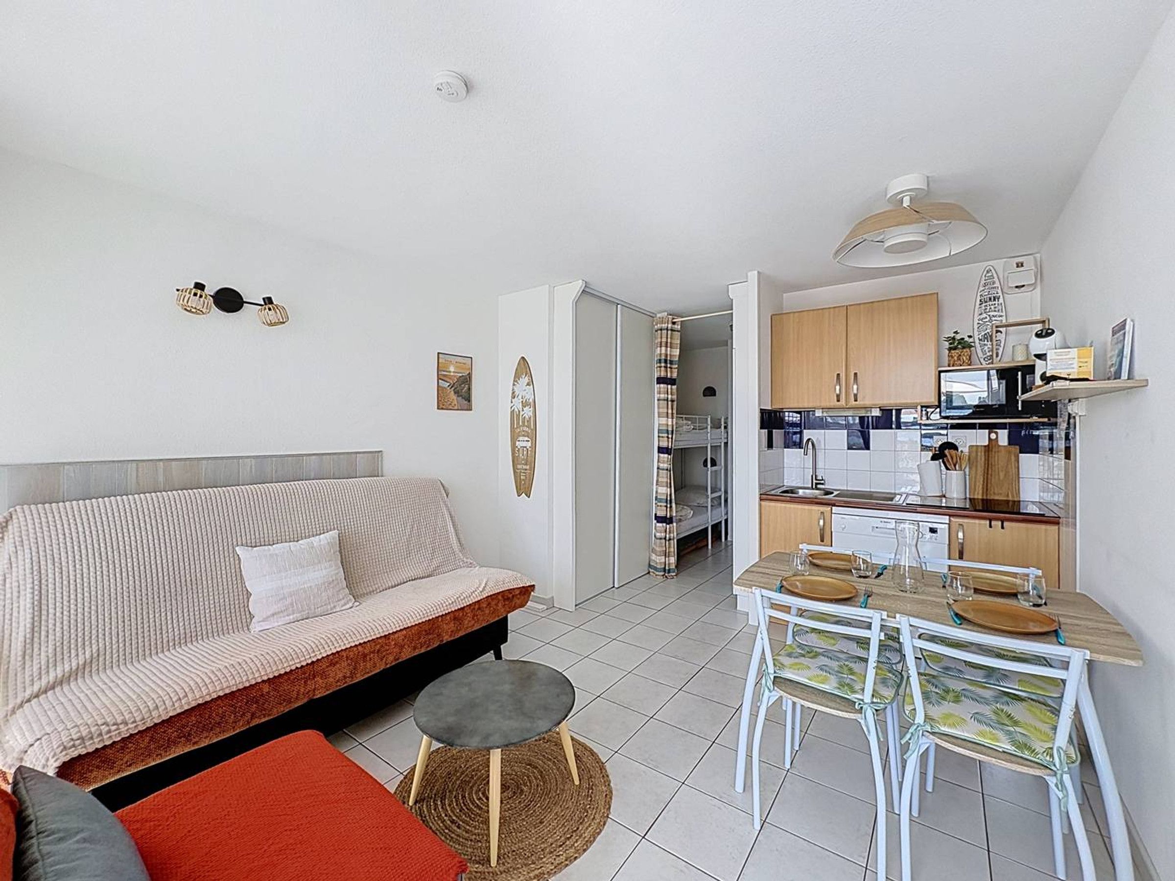 Um apartamento moderno com sala de estar, cozinha compacta e espaço para refeições.