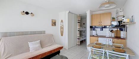 Eine moderne Wohnung mit Wohnbereich, einer Küchenzeile und einem Essbereich.