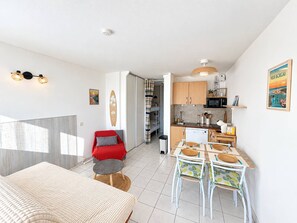 A compact living space with a kitchenette, a dining area, and a bedroom. - Studio with balcony - 4 guests (Vieux-Boucau-les-Bains)