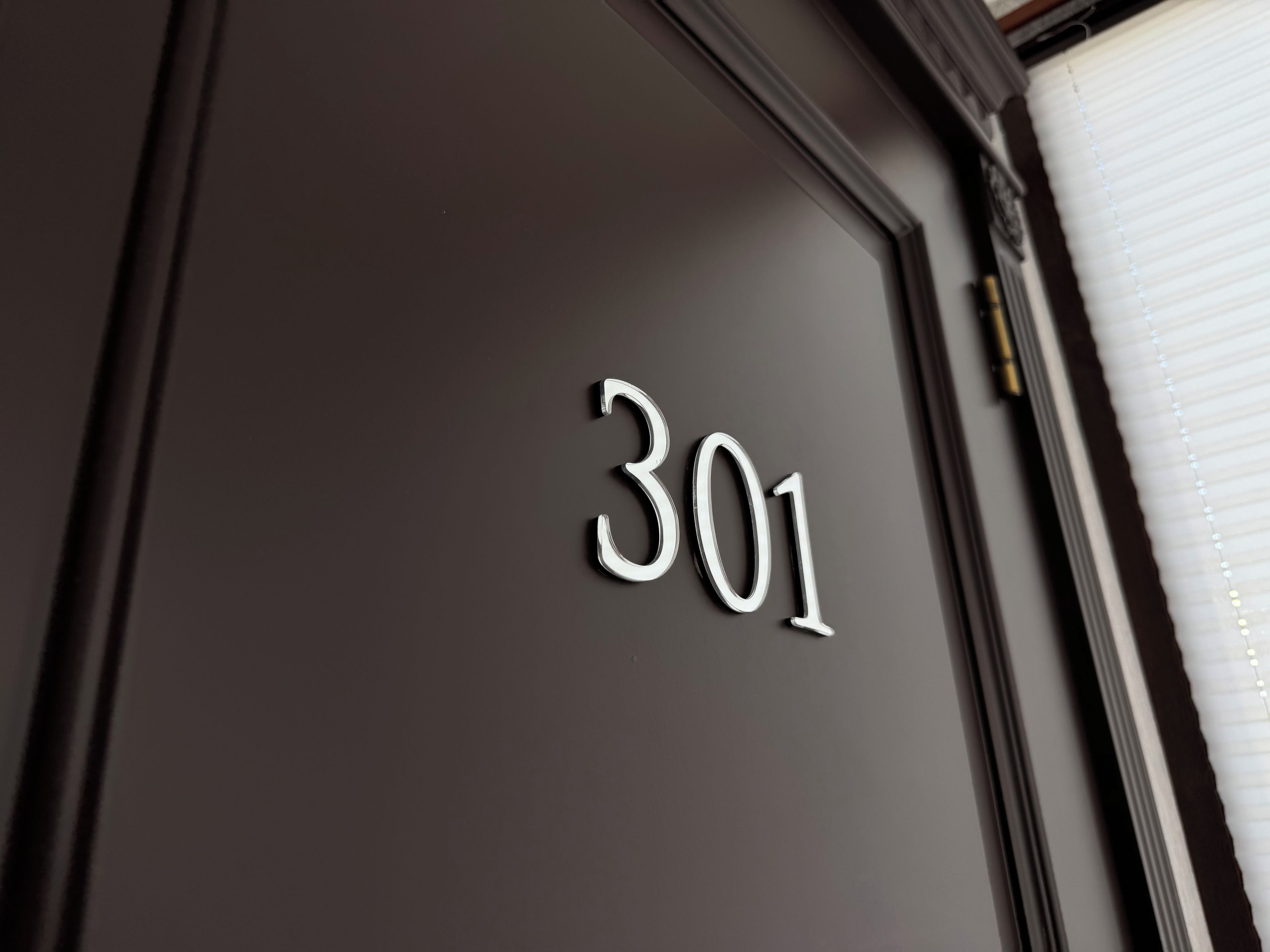 Eine dunkle Tür mit der Nummer 301 in weißer Schrift.