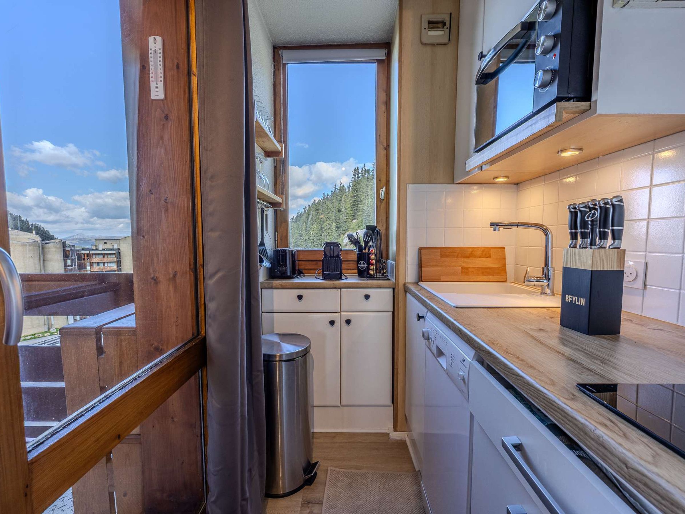 Cocina compacta con vistas al exterior, un microondas y un lavamanos.