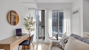 A modern living space with a desk, laptop, and seating area. - StayToronto - Work-Friendly 1BR Suite Steps to Eaton Centre (Toronto)