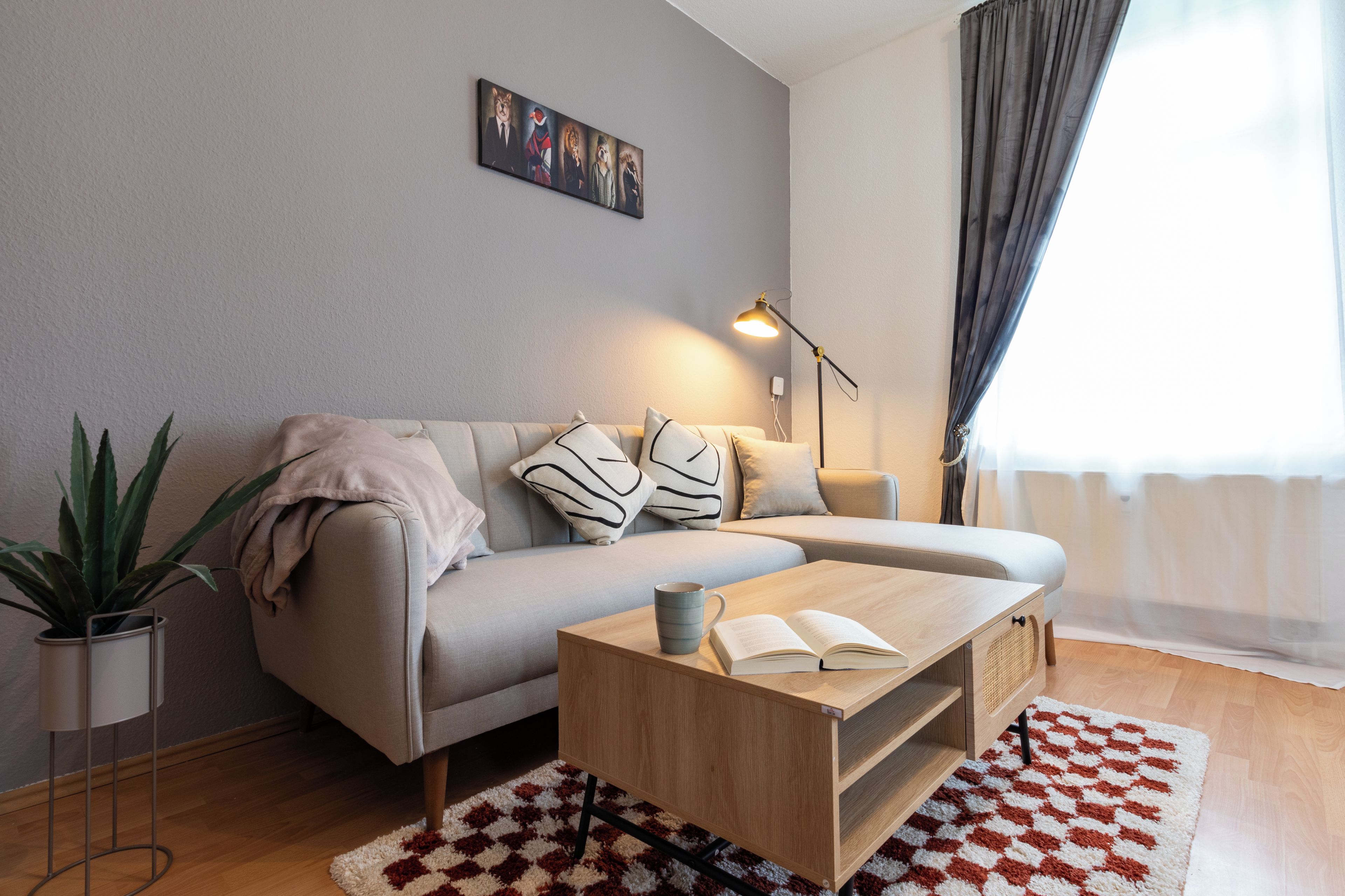 A modern living room with a sofa, a coffee table, a lamp, and a plant.