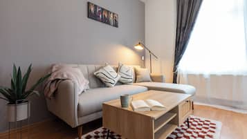 Ein modernes Wohnzimmer mit einer Couch, einem Couchtisch, einer Lampe und einer Pflanze.