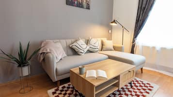Un salon moderne avec un canapé, une table basse, un lampadaire et une plante en pot.